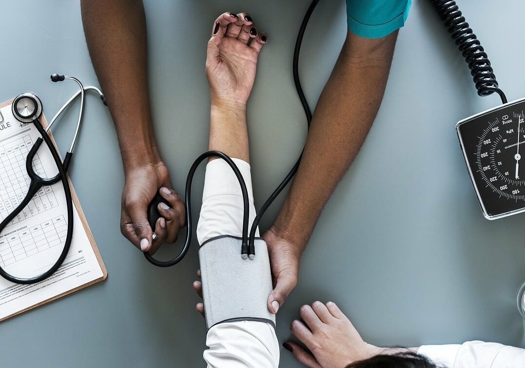 Doctor taking a patient's blood pressure - health insurance options for expatriates