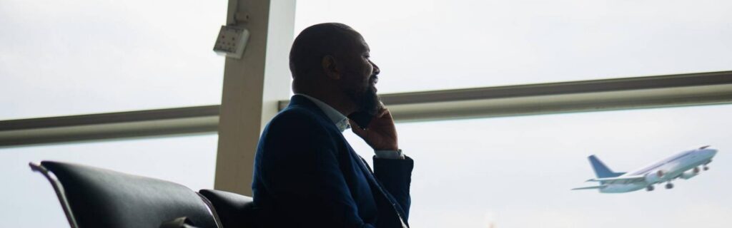 business travel on the phone at the airport with a plane in the background