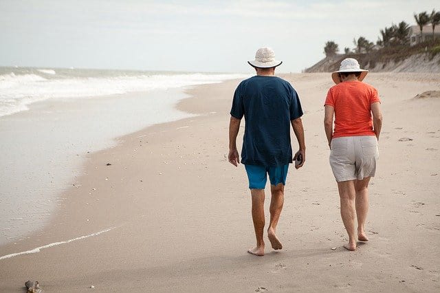 Elderly couple walking on the beach | GCS