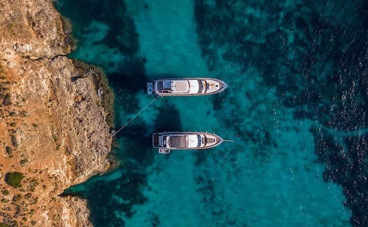 Aerial view of the ocean in Malta with two boats. 