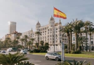 Spanish flag waving in the air in Alicante city on a sunny November afternoon in Spain - Digital nomad visa in Spain