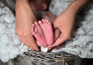 mother holding baby feet