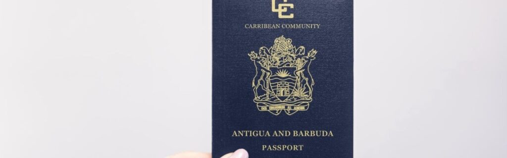 a person holding an antigua passport against a white background