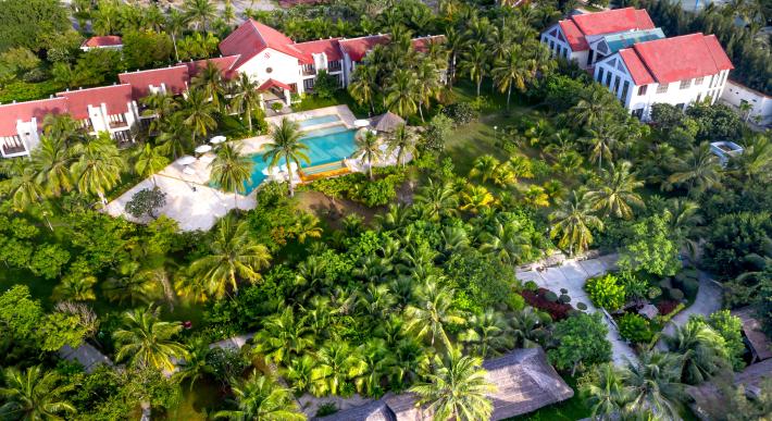 aerial view of antigua resort surrounded by greenery and with a pool in the center