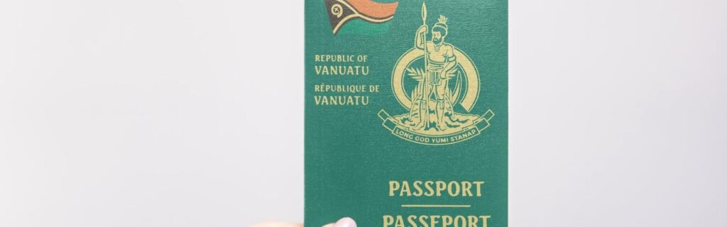 person holding a passport of vanuatu against a white background