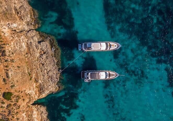 An view of the ocean with two white boats
