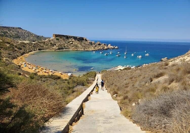 A pathway leading to the beach surrounded by mountains. 