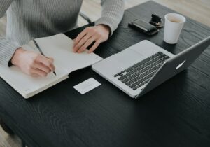 Man taking notes close to a computer