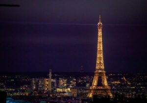 View of the Eiffel Tower lit up at night in Paris, France - retire in France as a US citizen