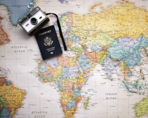 Camera and passport laying on a colorful map - Golden Visa for Indians