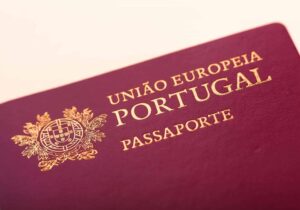 Close-up of a Portuguese passport with gold lettering and emblem on a burgundy cover.