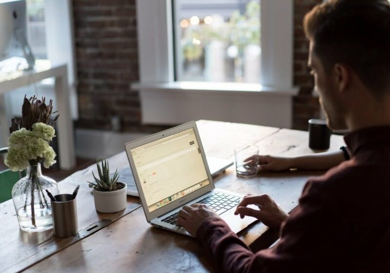 Man typing on a laptop at a desk - Digital nomads in Portugal