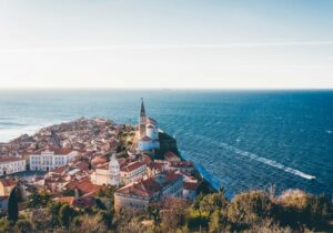 Brown roofed buildings on the ocean shoreline in Piran, Slovenia - best places to retire in the world