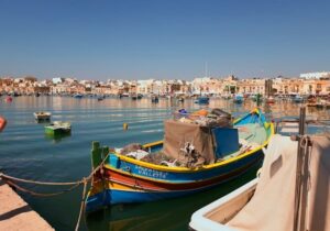 Boats moored in the ocean along the Malta shoreline - best country in Europe for retirement