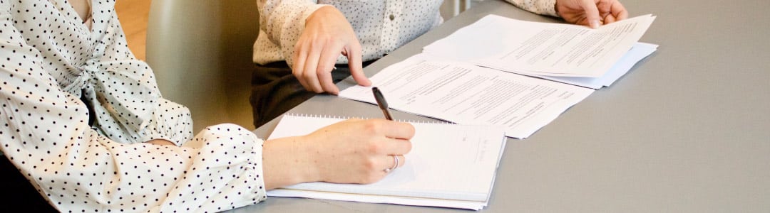 two people on a desk signing permanent residency Canada documents