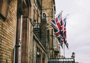 Union Jack flags hanging from an old building - student visas in Europe