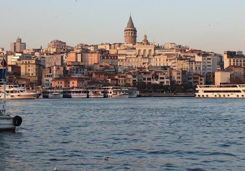 Buildings overlooking the ocean with boats nearby in Turkey. 