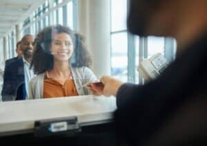 dark haired woman standing in front of a st kitts and nevis bank branch assistant opening account