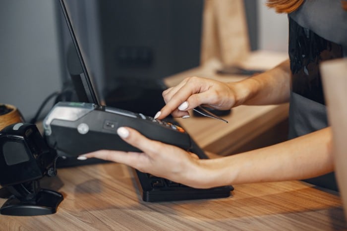 person holding a nevis bank point of sale terminal