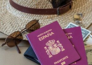 Two Spanish passports with sunglasses and a sunhat. 