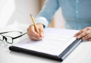 person at a table filling documents about Canada immigration backlogs 