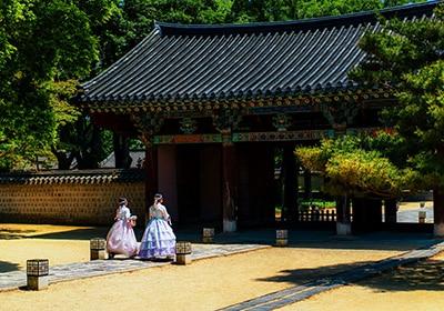 Two women in South Korea walking towards a place of worship wearing traditional dresses - safest countries in Asia for women