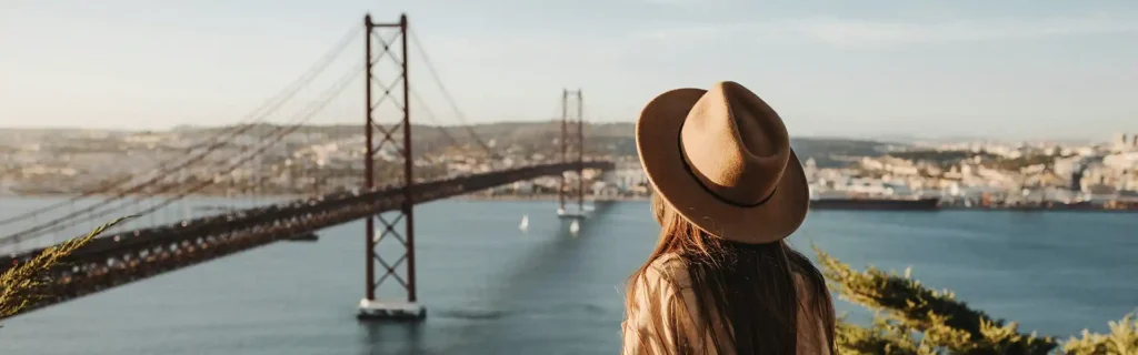 woman looking to Lisbon and the 25 Abril bridge