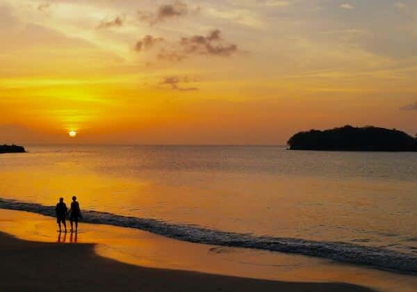 People walking at sunset on Sugar Beach in St. Lucia - country Americans are moving to