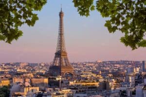 View of Eiffel Tower in Paris, France as seen through green trees - European countries to live in as an expat