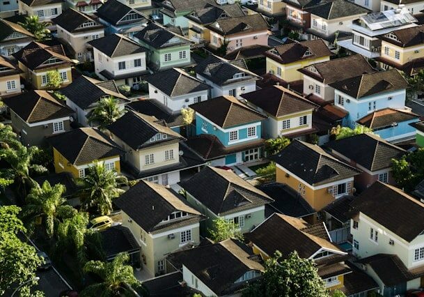 Many colorful houses with trees in between.