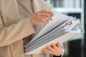 Person holding a stack of papers