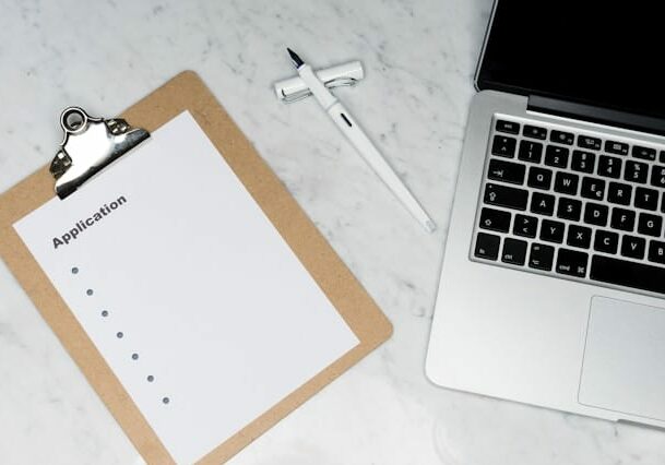 application form and a laptop on a desk