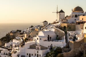 Traditional white Greek buildings overlooking the ocean - Retirement in Greece