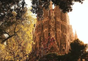 Low angle shot of the Expiatory Temple of the Holy Family surrounded by colorful trees during daytime - retiring in Spain