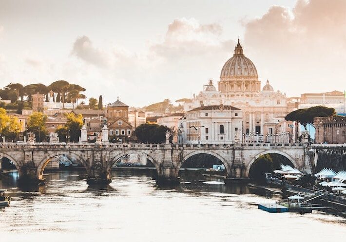 A view of the Florence Cathedral in Italy with a bridge and water in the foreground.