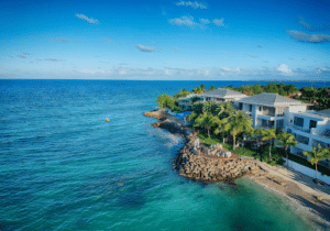 Ocean in Antigua and Barbuda with mansions dotting the shoreline - citizenship by investment fastest route