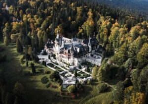 Bird's eye view of a castle in Romania surrounded by a forest - digital nomads in Romania