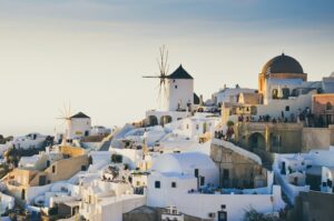 A coastal village with white houses on a hill overlooking the ocean. 