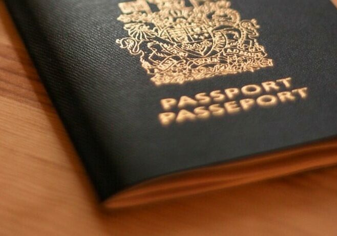 Black passport on a wooden desk - fastest citizenship by investment programs