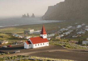 Church in Iceland with ocean and mountain in the background - least racist cold country