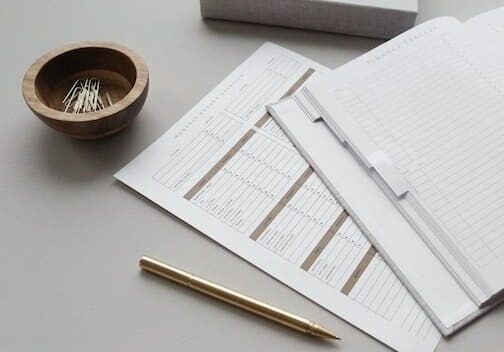 compliance documents on desk with pen and paper clips