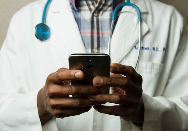 Portugal doctor looking at a mobile phone