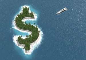 Boat in the ocean sailing towards a green island shaped like a dollar sign - Offshore banking definition