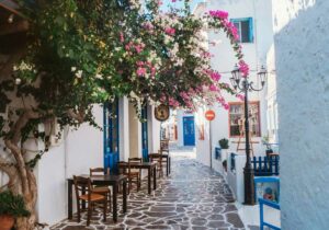 Pink flower tree on white concrete building on Greek Island of Milos - digital nomad taxes in Greece