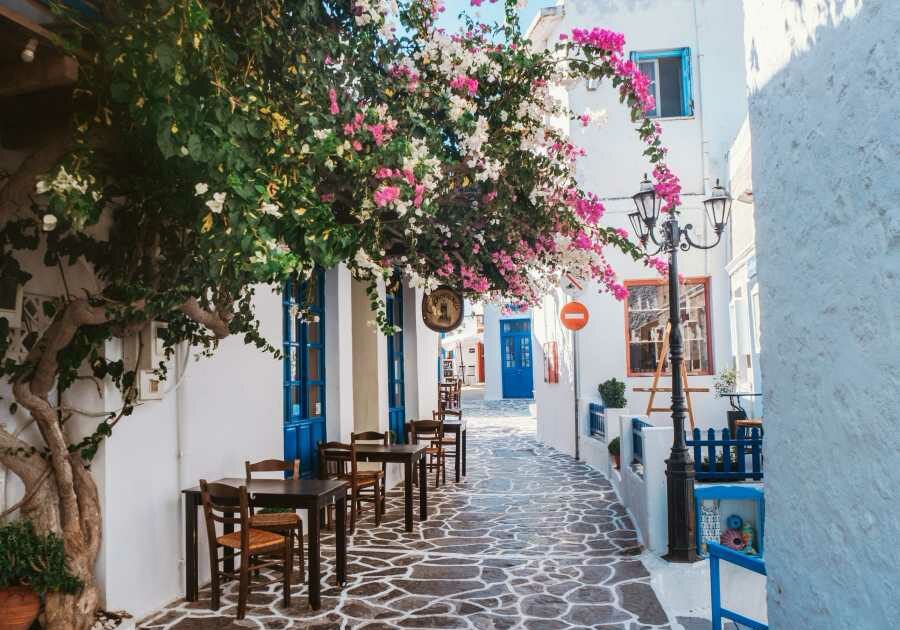 greece golden visa a narrow street in greece surrounded by white homes