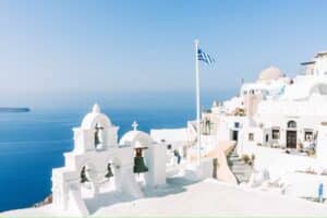 Classic Greek buildings against a bright blue ocean background - Europe countries to move to as an expat