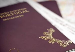 Close-up of a Portuguese passport placed on top of travel documents.