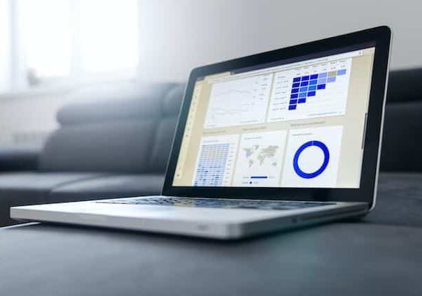 Computer on a gray sofa showing blue graphs - richest country in the world by GDP per capita
