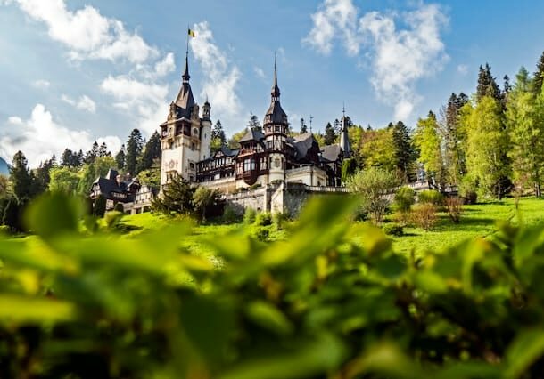 Castle in Sinaia, Romania with greenery in the foreground - cheap Southeastern European country to live in