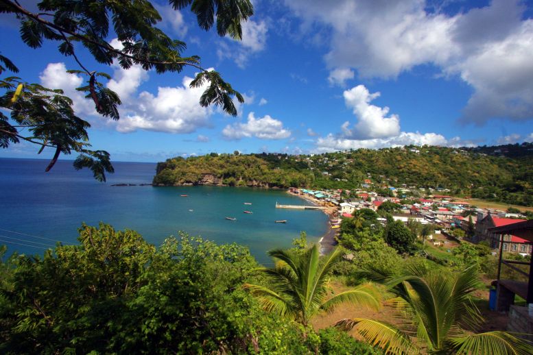 scenic view dominica coast town with greenery against a blue and cloudy sky